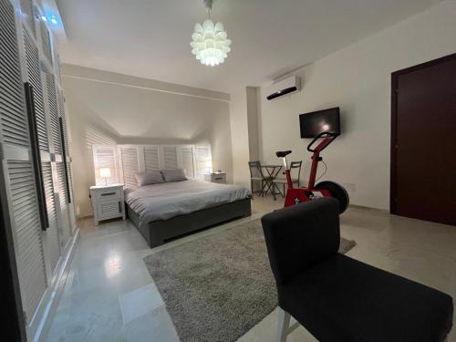 a bedroom with a bed and a chair and a television at New 2-room secure residence, beach, pool in Port El Kantaoui
