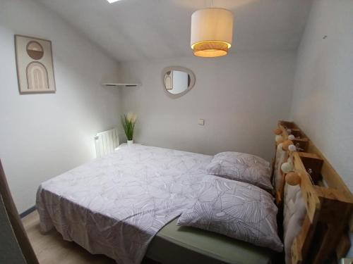 une chambre avec un lit avec une couette blanche dans l'établissement Joli appartement en centre ville et au calme, à Agen