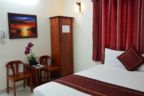 Lusa Guesthouse في دا نانغ: غرفة نوم بسرير وطاولة وكرسي