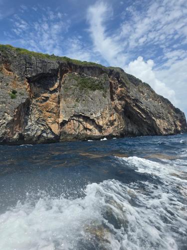 a rocky island in the ocean next to the water at Dreamvilles Ecovillage Las Galeras in Las Galeras