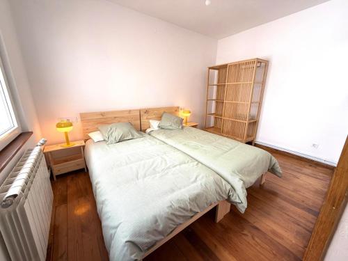 Un dormitorio con una cama grande y suelo de madera. en Apartamento a Un Paso de la Playa de Tapia, en Tapia de Casariego