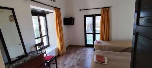 a bedroom with a bed and a mirror and two windows at Las Magnolias in San Miguel