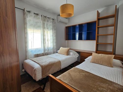 a bedroom with two beds and a window at Casa Saki in Armilla