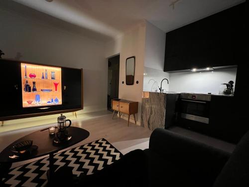 a living room with a tv and a kitchen at Apartament Rockabilly in Stalowa Wola