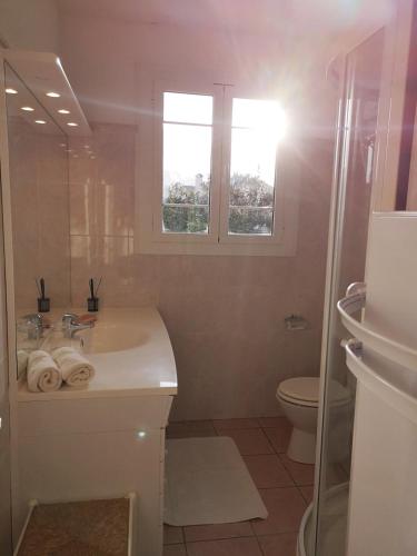 a white bathroom with a sink and a toilet at Le cœur de saint Florent in Saint-Florent