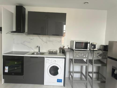 une cuisine avec un lave-linge et un micro-ondes dans l'établissement Nice and warm studio to relax, à Hellemmes-Lille