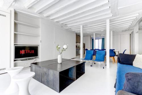 un salon avec un canapé et une télévision dans l'établissement Appartement Rue Montorgueil Calme et Design, à Paris