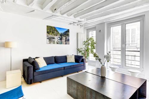 un salon avec un canapé bleu et une table basse dans l'établissement Appartement Rue Montorgueil Calme et Design, à Paris