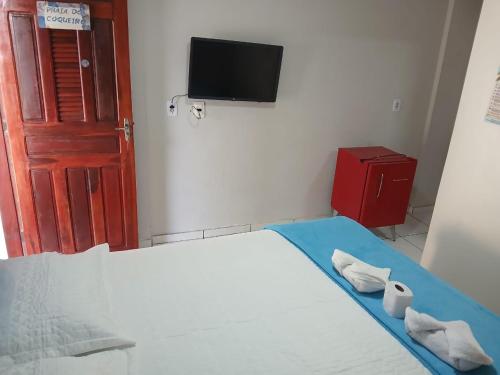 a bedroom with a bed and a tv on the wall at Pousada Canto do Mar Luís Correia in Luis Correia