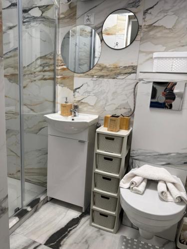 a bathroom with a toilet and a sink and mirrors at Mieszkanie Ratownika in Dziwnów