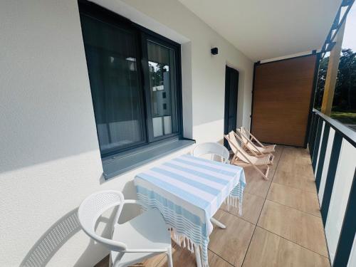 a balcony with a table and chairs on it at Rodzinny Apartament przy plaży, Bezpłatny parking Dąbki in Dąbki