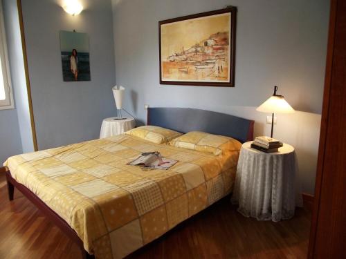 フィナーレ・リーグレにあるCasa Azzurro Pervinca by Holiday Worldのベッドルーム1室(ベッド1台、ランプ付きテーブル2台付)