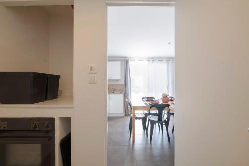a person sitting at a table in a kitchen at TY AR PARIZ T3 Rennes centre Parc du Thabor in Rennes