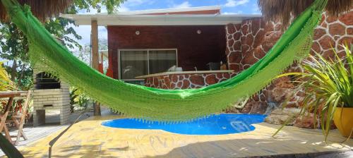 a hammock on the patio of a house at chalé com cozinha dois quartos e piscina privativa in Fortim