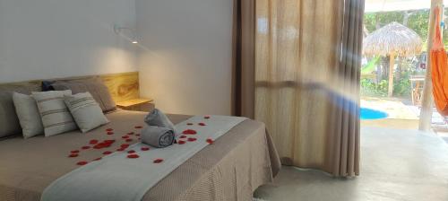 a bedroom with a bed with red roses on it at chalé com cozinha dois quartos e piscina privativa in Fortim