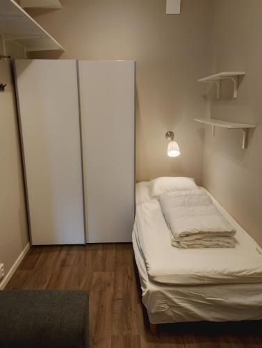 a bedroom with a bed with a closet and a lamp at Cozy cottage with lake view in Grimeton