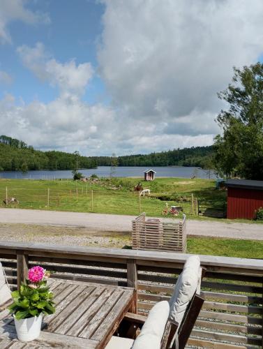a patio with a table and chairs and a lake at Cozy cottage with lake view in Grimeton