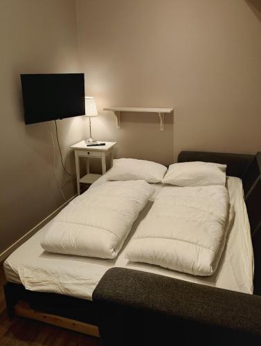a bed with two pillows on it in a room at Cozy cottage with lake view in Grimeton