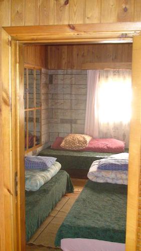 four bunk beds in a room with a window at Tammekännu Holiday House in Mammaste