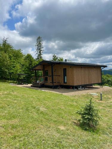 a large wooden cabin with a grassy field at Kosuli in Oriv