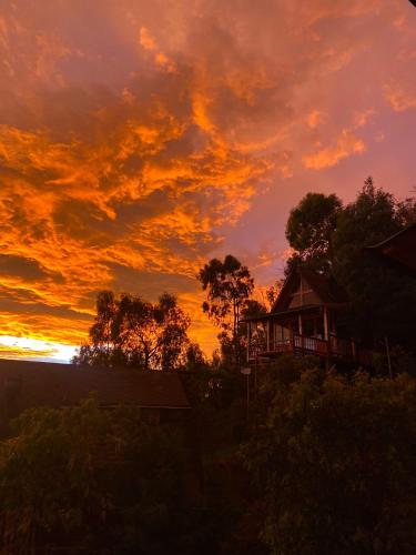 a sunset with a house in the foreground at Skyline Ecoliving Santa Elena in Santa Elena