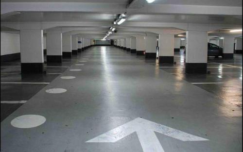 an empty parking garage with a white arrow on the floor at New 2-room secure residence, beach, pool in Port El Kantaoui
