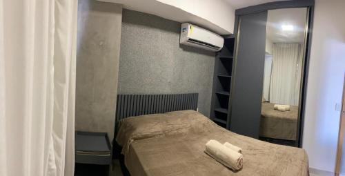 a small bedroom with a bed and a mirror at Unique studio - loft aconchegante e bem localizado in Belém