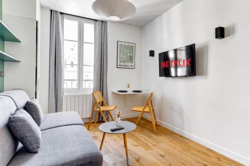 un salon avec un canapé et une table dans l'établissement BM Rue Charlot Studio compact & chic pour 2, à Paris