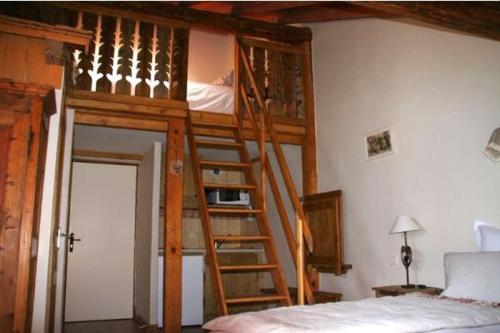 Litera de madera en un dormitorio con escalera en Auberge de Cassiel, en La Côte-dʼAime