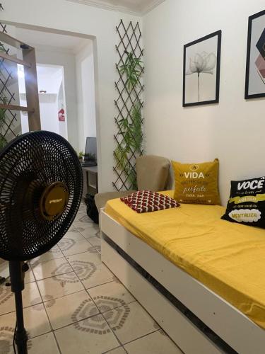 a bedroom with a yellow bed and a chair at Pousadinha Mel - Centro de Convenções in Salvador