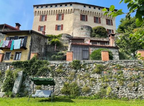 an old building on a stone wall with a yard at Il Nido Del Ricetto in Roppolo