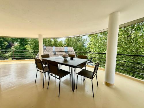 une salle à manger avec une table et des chaises sur un balcon dans l'établissement La Tour du Lac, gîte bel & spacieux à côté du lac de Gerardmer, à Gérardmer