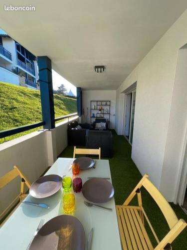 - une table blanche avec des assiettes et des chaises dans le salon dans l'établissement T2 Acotzeta classé 3 étoiles Saint Jean de Luz quartier Acotz près des plages, à Saint-Jean-de-Luz