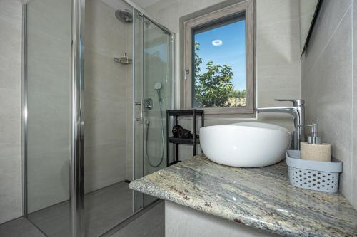 a bathroom with a sink and a shower at Villa Mandarin Paradise with sea view in Pinezici