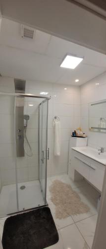 a white bathroom with a shower and a sink at Studio Pachamama in Rotenburg an der Wümme