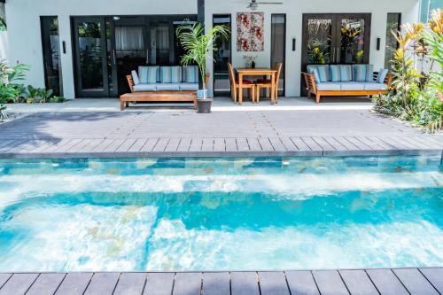 a swimming pool with chairs and a table at The Logan Playa Samara in Sámara