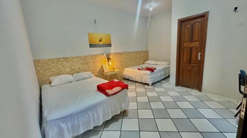 a bedroom with two beds and a tiled floor at Casa Piauí Hostel in Teresina