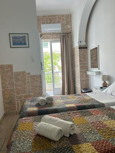 a bedroom with a bed with towels on it at ERRIKA in Ermoupoli