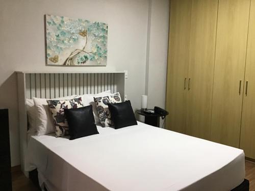 a bedroom with a large white bed with pillows at Exelente Apart hotel otima localizaçao in Brasilia