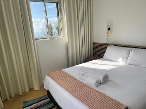a bedroom with a bed with two towels on it at Villa do Monte Sunset in Porto Moniz