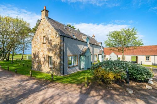 an old stone house in the middle of a street at At The Bay in St. Andrews