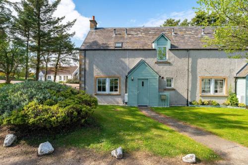 a house with a green door on a yard at At The Bay in St. Andrews