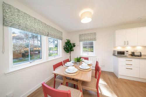 a kitchen and dining room with a table and chairs at At The Bay in St. Andrews