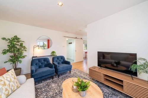 a living room with two blue couches and a tv at At The Bay in St. Andrews