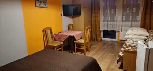 a room with a table and chairs and a tv at Róża Wiatrów 2 Władysławowo in Władysławowo