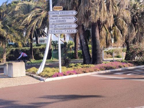 a street sign with many street signs on a pole at NEW! Sea View studio - Beachfront living in Cannes, Boulevard du Midi - Nouveau! Studio Vue mer, face à la plage, les pieds dans l'eau in Cannes
