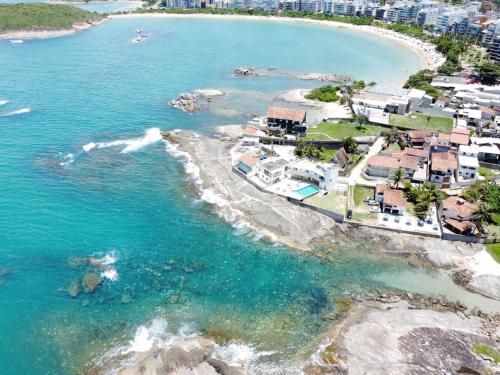 an aerial view of a beach with houses and the ocean at Casa Pé na Areia 027 QUARTO CASAL 1 in Guarapari