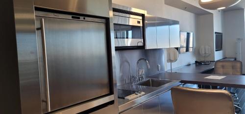 a kitchen with a stainless steel refrigerator and a table at Palms Place Luxury 35th Floor Unit with Amazing Strip View in Las Vegas