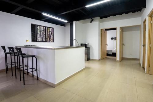 a kitchen with a counter and stools in a room at Coliving Tonchalá Laureles Habitaciones y Apartamentos Familiares con Cocina cerca del Estadio in Medellín