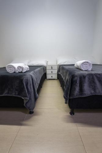 two beds sitting next to each other in a room at Coliving Tonchalá Laureles Habitaciones y Apartamentos Familiares con Cocina cerca del Estadio in Medellín